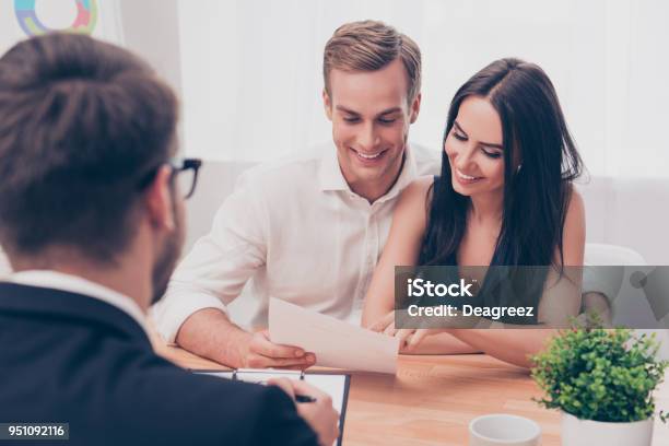 Successful Lawyer Giving Consultation To Family Couple About Buying House Stock Photo - Download Image Now