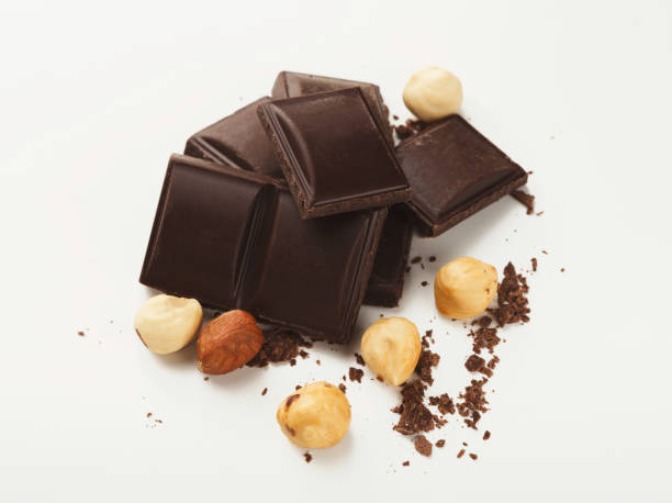 istock Broken dark chocolate bar and hazelnut isolated on white 951094304