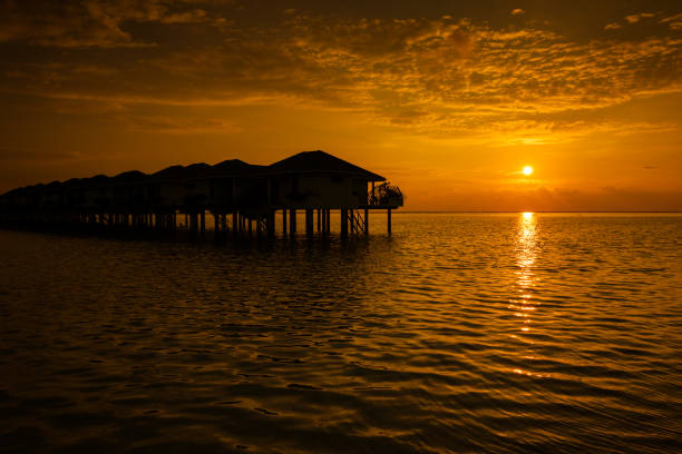 istock Maldives sunset with water villas silhouette 951094880