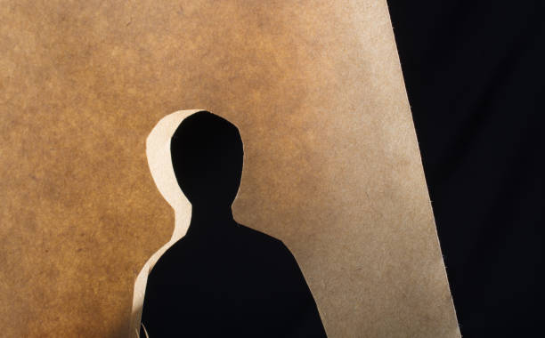 Man shape cut out of paper in hand