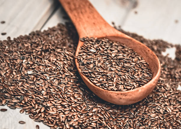 istock Flax seeds in a wood spoon. Linseed is scattered. 951100512