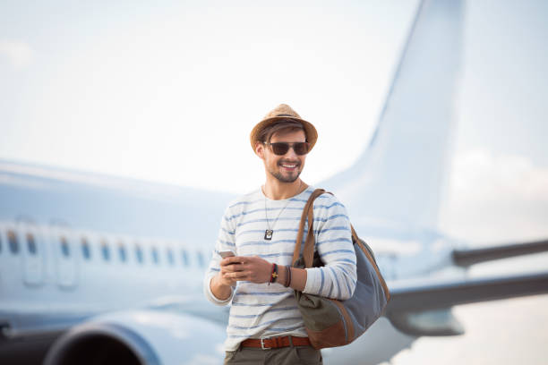 istock Handsome young guy in front of an airplane 951101444