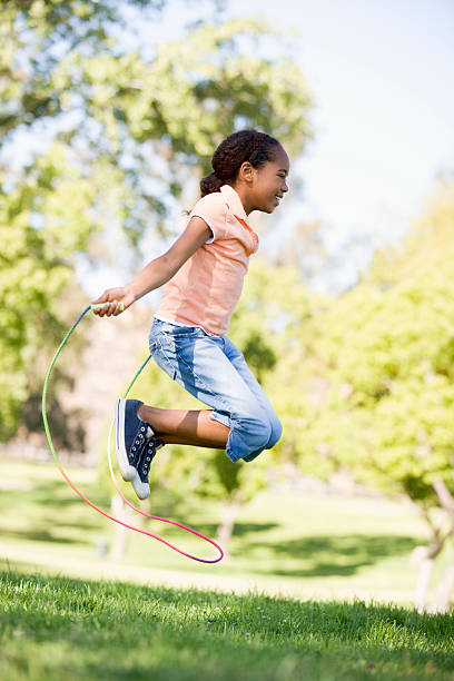Girl outside using skipping rope  jump rope stock pictures, royalty-free photos & images