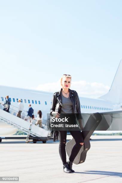 Female Musician Standing In Front Of An Airplane Stock Photo - Download Image Now - Airport, Guitar, Musician