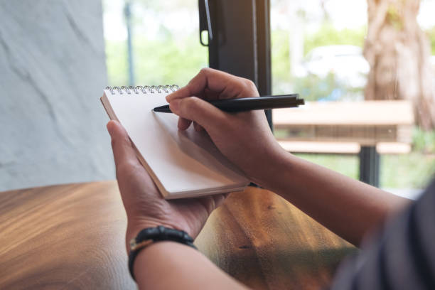 istock Closeup image of a woman's hands writing down on a white blank notebook 951105578