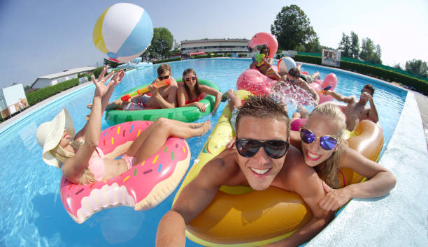 selfie: 陽気な笑顔の友人に selfie を作る楽しいプールでカラフルな floaties - celebration inflatable excitement concepts ストックフォトと画像