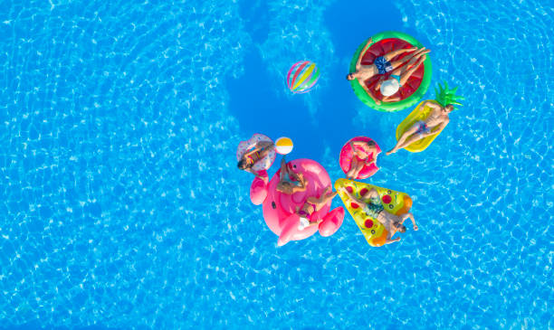 istock AERIAL: Happy young friends playing water volleyball on fun floaties in pool 951105778