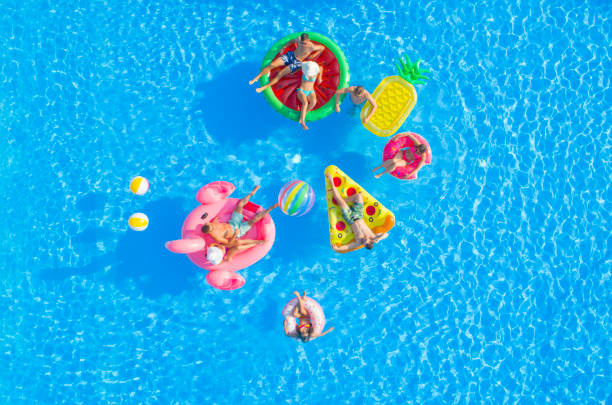 istock AERIAL: Couples and friends hanging out on fun floaties in luxury resort pool 951105798