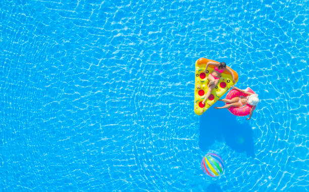 istock AERIAL Girlfriends enjoying on fun inflatable pizza and doughnut floats in pool 951105868