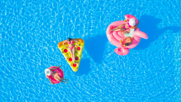 istock AERIAL, TOP DOWN: Friends on summer vacation chilling on floaties in the pool 951105872