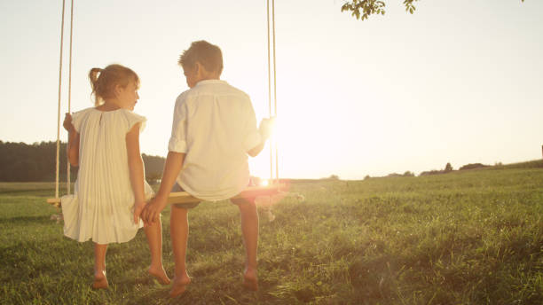 istock COPY SPACE: Young couple holding hands on swing at golden sunset 951106044