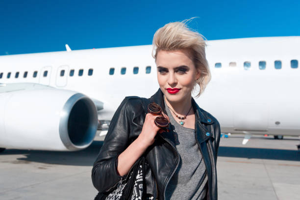 istock Attractive woman in front of airplane 951106372