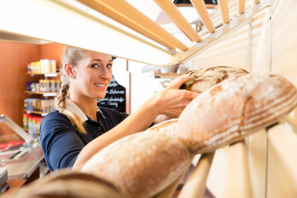 istock Bakery woman putting bread in shop shelf 951109642