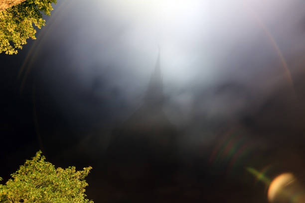 Beautiful view of the shadow in the clouds at night of historic landmark Le Mont Saint-Michel in Normandy, France, a famous UNESCO world heritage site and tourist attraction