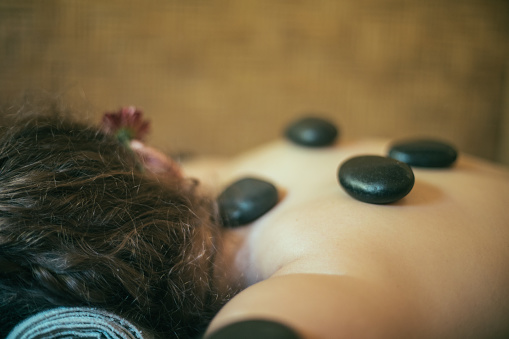 Woman at spa hot stone therapy