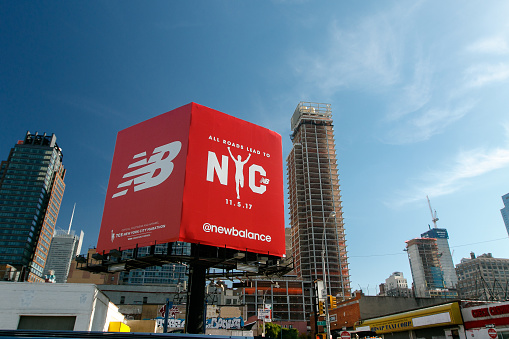 New York, October 27, 2017: Big red billboard for New Balance sports footwear manufacturer that also announces the NYC marathon.