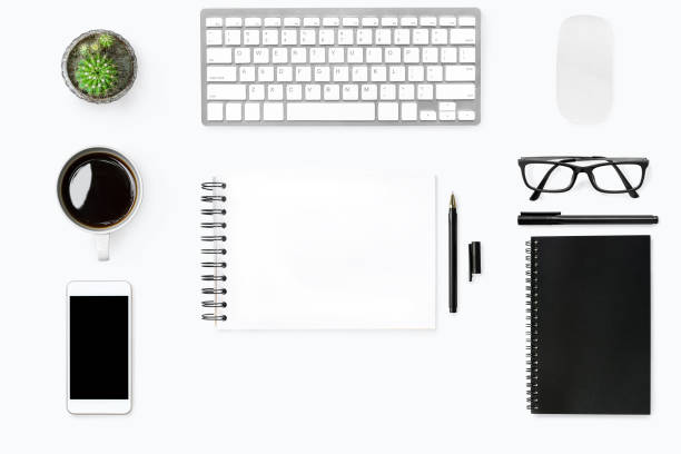 istock White desk table with blank notebook in the middle with supplies. Top view, flat lay. 951126770