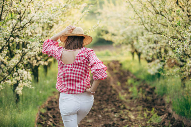 istock Young woman standing in the orchard 951128494