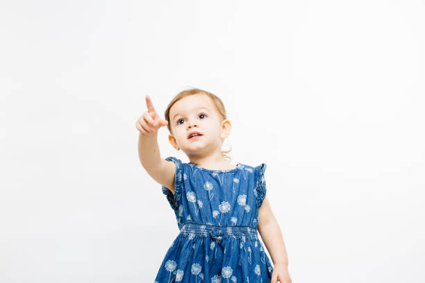 istock What is that? - Little girl pointing and looking up with a curious expression 951128956