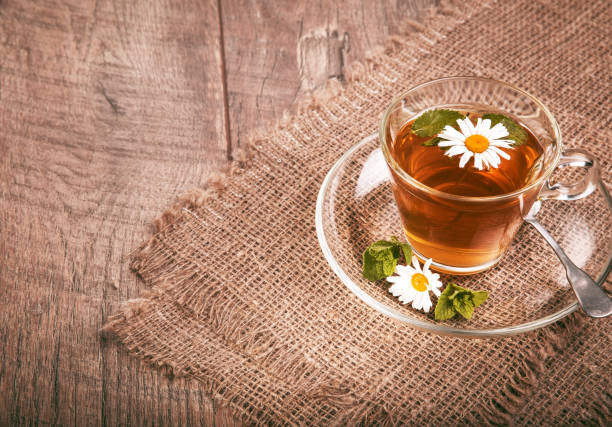istock Cup of medicinal chamomile tea on a wooden 951133630