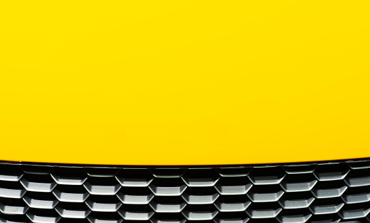 Abstract of yellow car hood with black hive pattern
