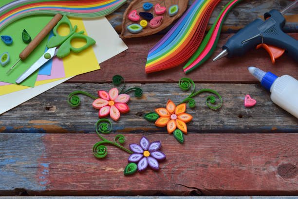 Quilling technique. Paper strips, flowers, scissors, elements. Handmade crafts on holiday theme: Birthday, Mother's Day, March 8, Wedding. Making decoration or greeting card. Children's DIY concept.