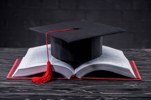 istock Open book with graduation cap on wooden table 951143974