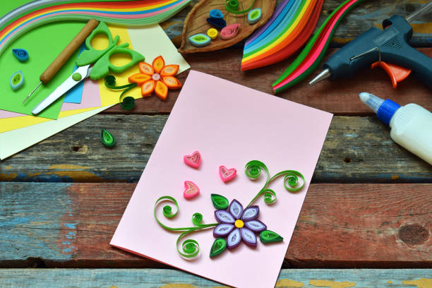 istock Quilling technique. Paper strips, flowers, scissors, elements. Handmade crafts on holiday theme: Birthday, Mother's Day, March 8, Wedding. Making decoration or greeting card. Children's DIY concept. 951144078