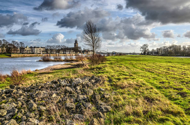 Grass covered floodplains of the IJssel river at low tide with the city of Deventer, The Netherlands in the background