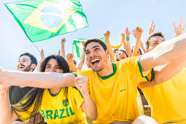Brazilian supporters celebrating at stadium with flags stock photo