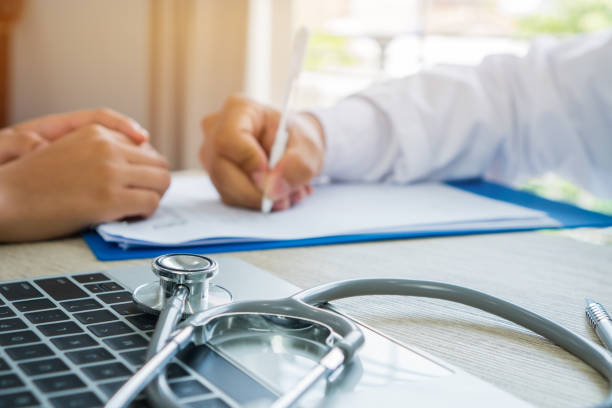 Healthcare medical concept. Doctor writing prescription clipboard with record information paper and patient listening receiving prescriptions medicine in doctor's office. Focus stethoscope computer concepto médico profesional de la salud. médico portapapeles de prescripción con el papel de la información del registro y escucha paciente recibir medicina de receta en el consultorio del médico de la escritura. equipo estetoscopio de enfoque