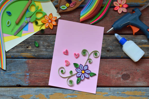 istock Quilling technique. Paper strips, flowers, scissors, elements. Handmade crafts on holiday theme: Birthday, Mother's Day, March 8, Wedding. Making decoration or greeting card. Children's DIY concept. 951149600