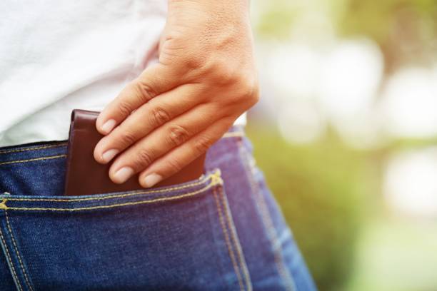 uomo sicuro in posa per salvare tenendo il portafoglio nella tasca posteriore dei pantaloni tascabili della schiena jean. risparmio di denaro. - tasca foto e immagini stock