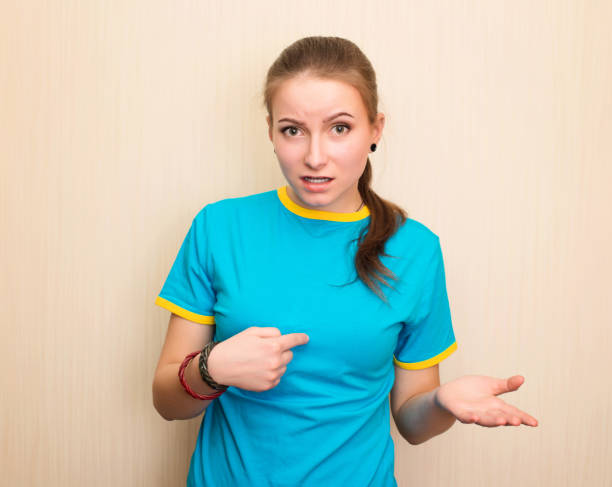 istock Confused young girl shrugging shoulders and looking at camera after she did something wrong but not feeling sorry or guilty 951150914