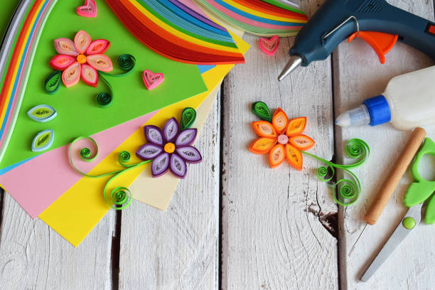 istock Quilling technique. Paper strips, flowers, scissors, elements. Handmade crafts on holiday theme: Birthday, Mother's Day, March 8, Wedding. Making decoration or greeting card. Children's DIY concept. 951153512