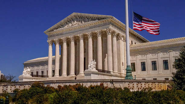 Supreme Court of the United States and American Flag in Washington, DC Wide View of the United States Supreme Court with American Flag - Washington DC us supreme court stock pictures, royalty-free photos & images