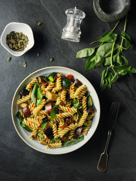 gesunde vegane pastaschüssel mit gebratenem gemüse - pasta directly above fusilli food stock-fotos und bilder
