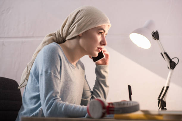 istock side view of young woman in kerchief talking by smartphone and taking notes 951154780