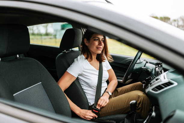 foto von einer business-frau sitzen im auto, auf ihren sicherheitsgurt. - sicherheitsgurt teil eines fahrzeugs stock-fotos und bilder