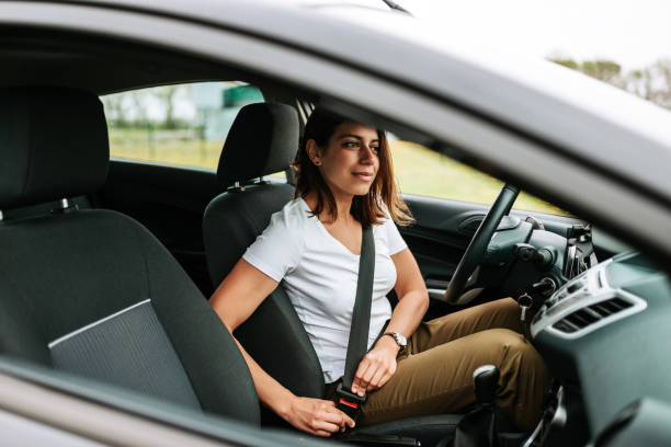 фотография бизнес-женщины, сидящей в машине, присовытив ремень безопасности. - seat belt стоковые фото и изображения