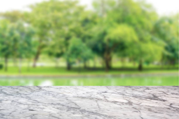 istock Empty top White marble Table and blurred green nature background. For present your products display 951158360