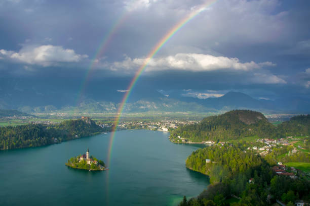 istock Scenic panoramic view of Lake Bled from above with double rainbow on the sky 951159264