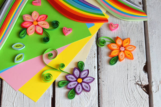 istock Quilling technique. Paper strips, flowers, scissors, elements. Handmade crafts on holiday theme: Birthday, Mother's Day, March 8, Wedding. Making decoration or greeting card. Children's DIY concept. 951162892