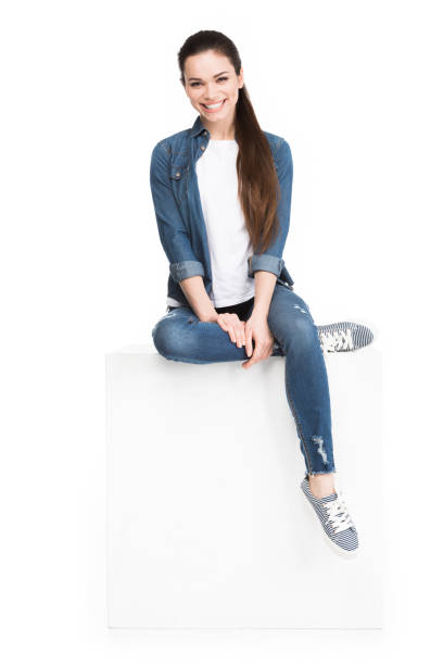 istock attractive brunette woman sitting on white cube, isolated on white 951164946