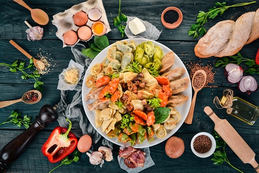 Set of Ukrainian cuisine. Vareniks, fresh vegetables, spices. Top view. On a wooden background. Copy space.