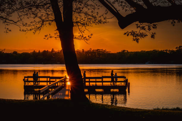 Silohoutte of a dock and trees during sunset at a lake in Minnesota