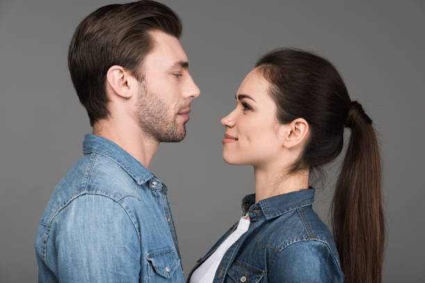 istock young couple looking at each other, isolated on grey 951167870
