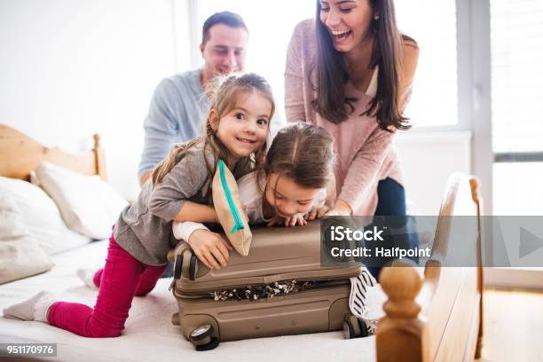 Young Family With Two Children Packing For Holiday Stock Photo - Download Image Now