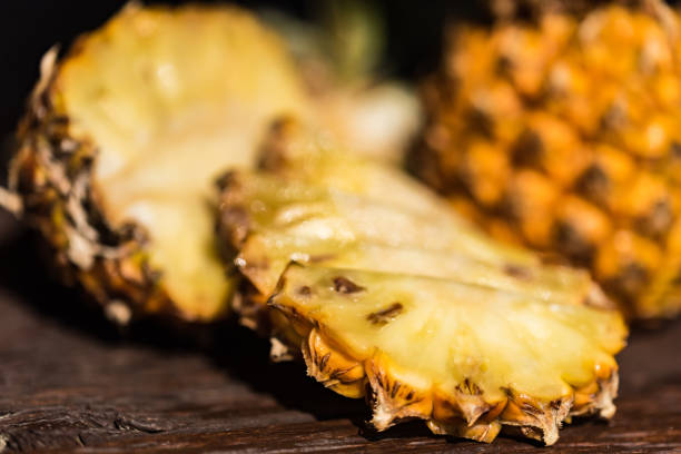 istock Pineapples on a dark wooden background 951172414