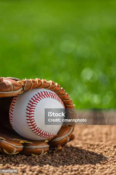 A Closeup Of A New Baseball In A Sports Glove Sitting In The Dirt Stock Photo - Download Image Now